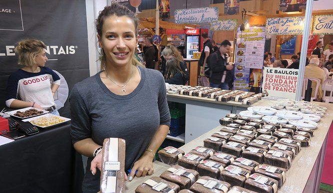 Jeune femme derrière son stand de gâteau Baulois 