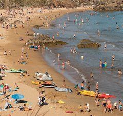 plage noire de vacanciers en été